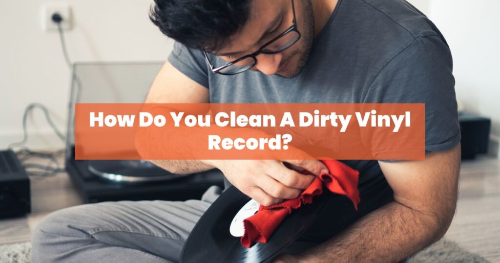 a man cleaning vinyl record with a red cloth 